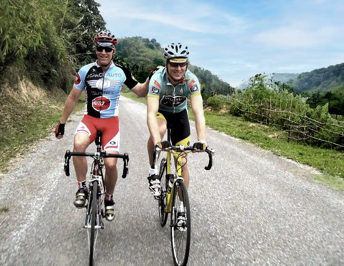 Cyclists riding through Northern Laos on a road bike tour from Hanoi to Luang Prabang.